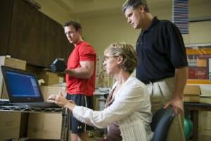 HSU student lifting weight while professor uses pc device to measure performance